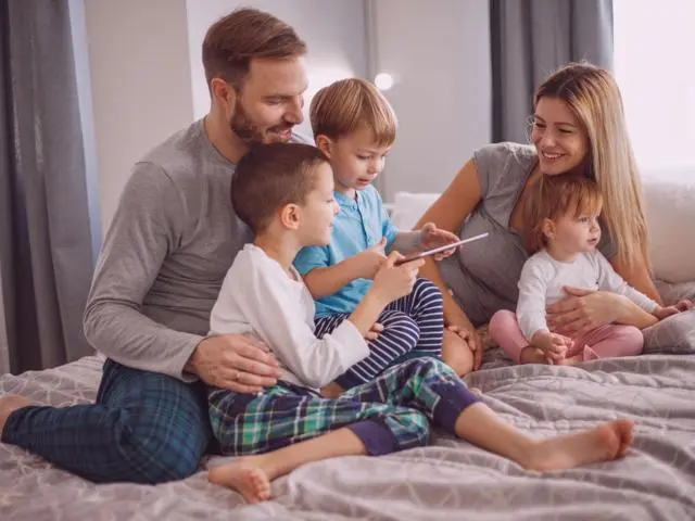 Couple with two boys and a little girl in bed